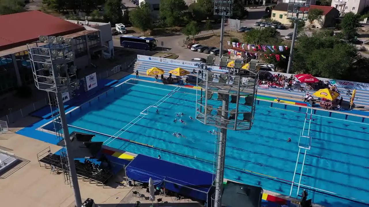 water polo match in large swimming pool at sunny summer