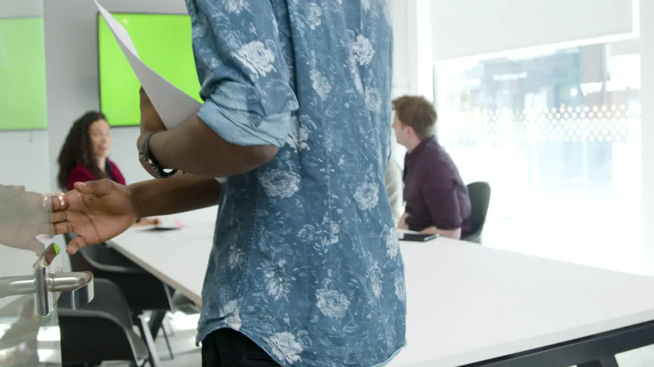 Man Walking Into A Business Meeting With Colleagues