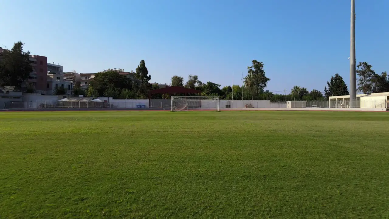 A POV view of a drone at a football field sprinting from the middle of the field to the goal post