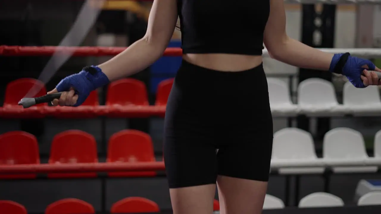 Female Boxer With Her Hands Wrapped In Bandage Jumping On The Skipping Up From Below