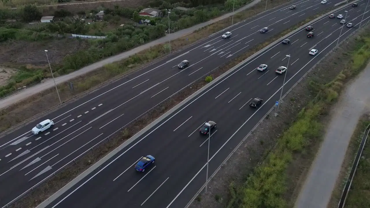 Aerial drone shot of a highway on the outskirts of the city of Barcelona with cars driving