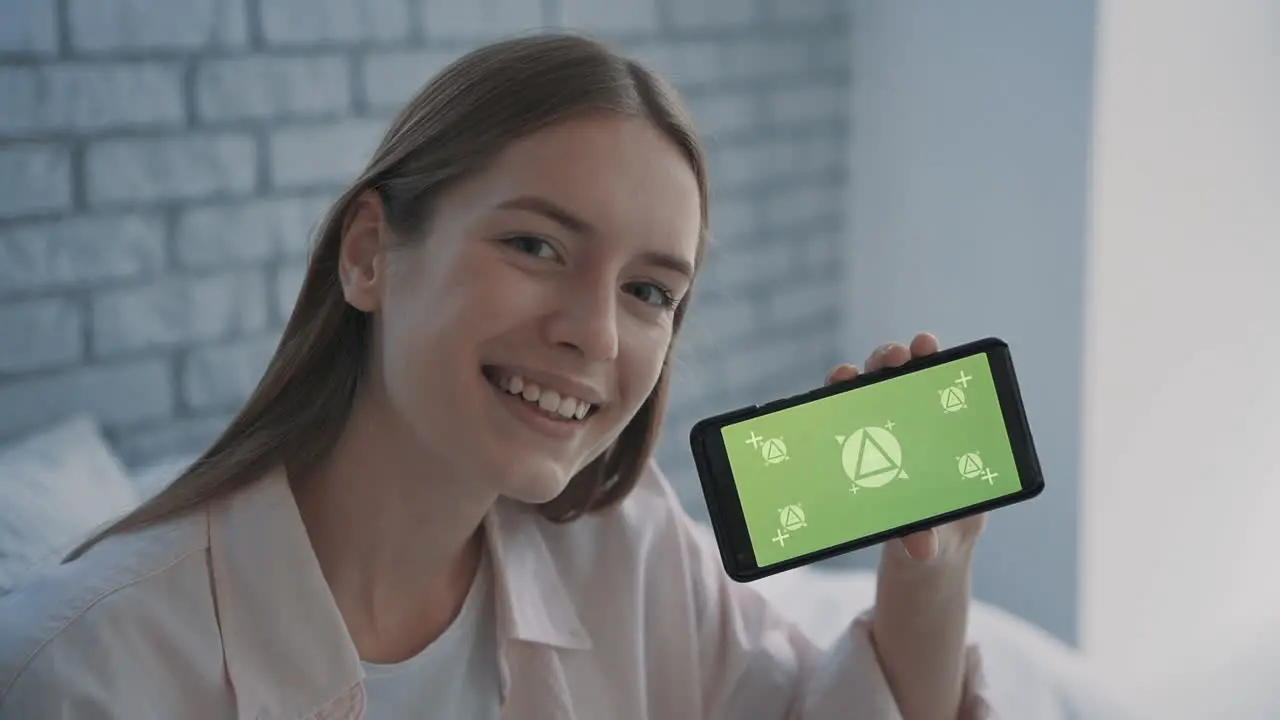 Portrait Of A Pretty Young Woman Holding A Phone With Mockup Green Screen