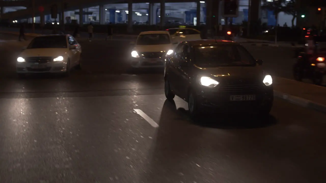 Taxi cab and other cars and vehicles driving at night in downtown city of Dubai