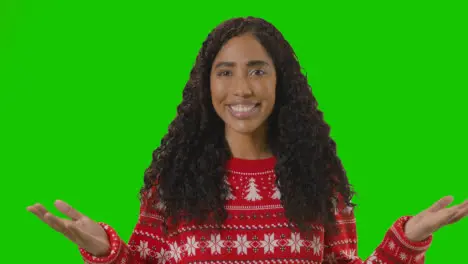 Studio Portrait Of Woman Wearing Christmas Jumper Against Green Screen Smiling At Camera Saying Merry Christmas 2