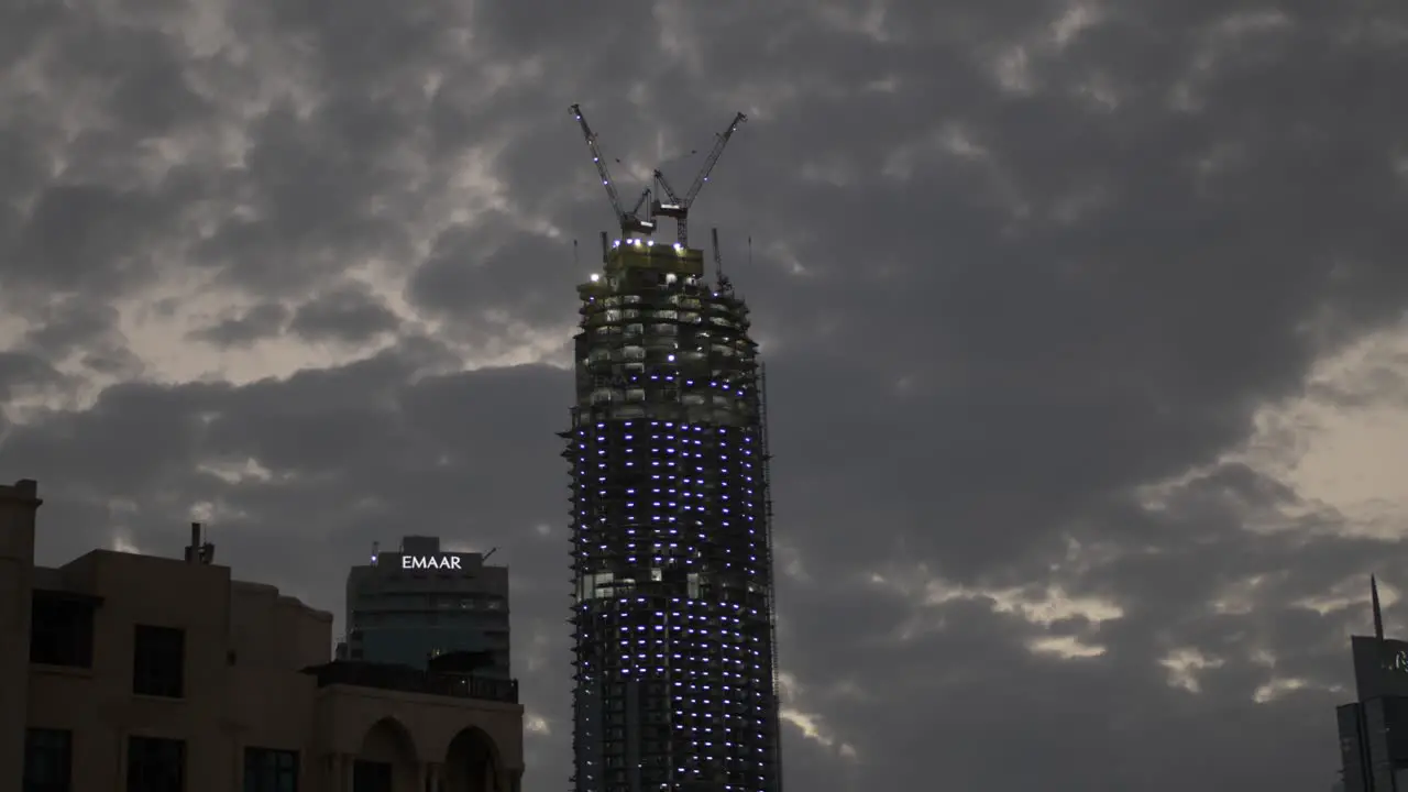 Lit up skyscraper under construction in the city of Dubai