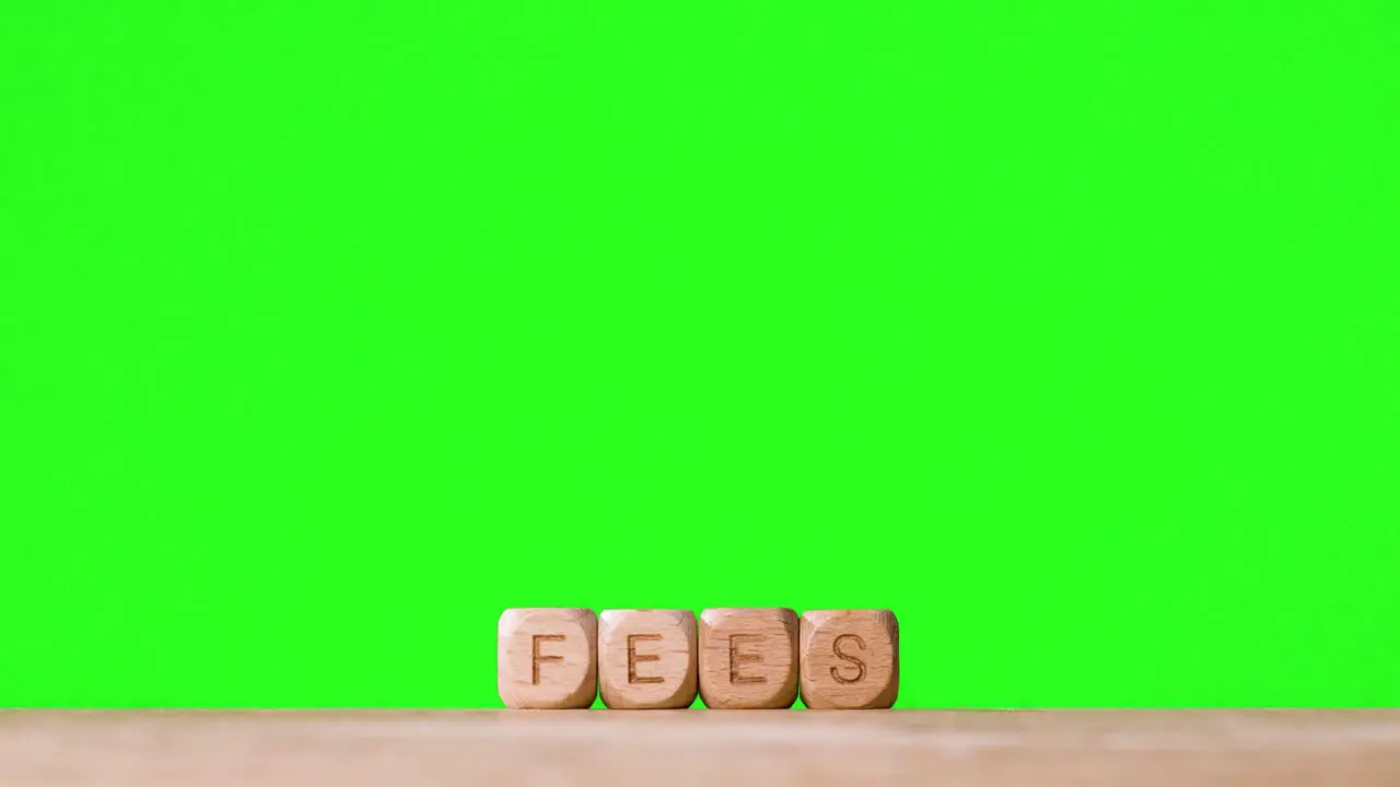 Education Concept With Wooden Letter Cubes Or Dice Spelling Fees Against Green Screen