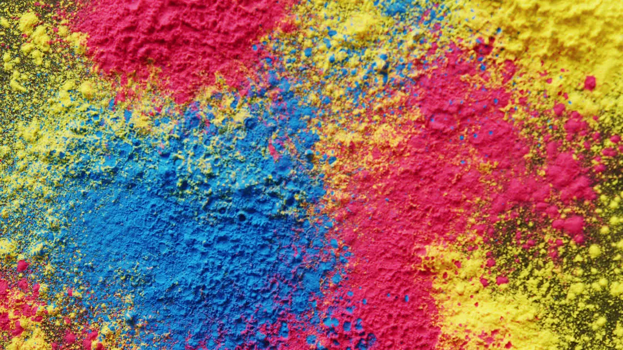 Video of close up of multi coloured powders with copy space on black background