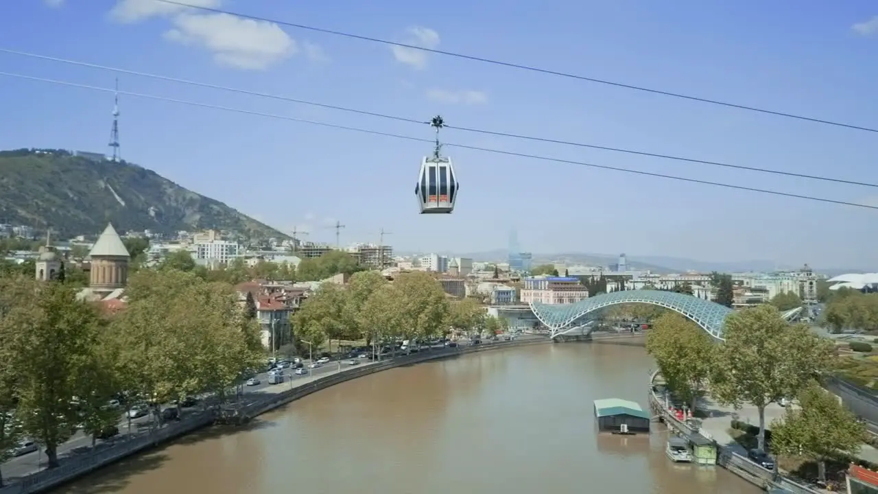 Tbilisi aerial view on a funicular over Mt'k'vari River autumn view cars passing by old town glass bridge