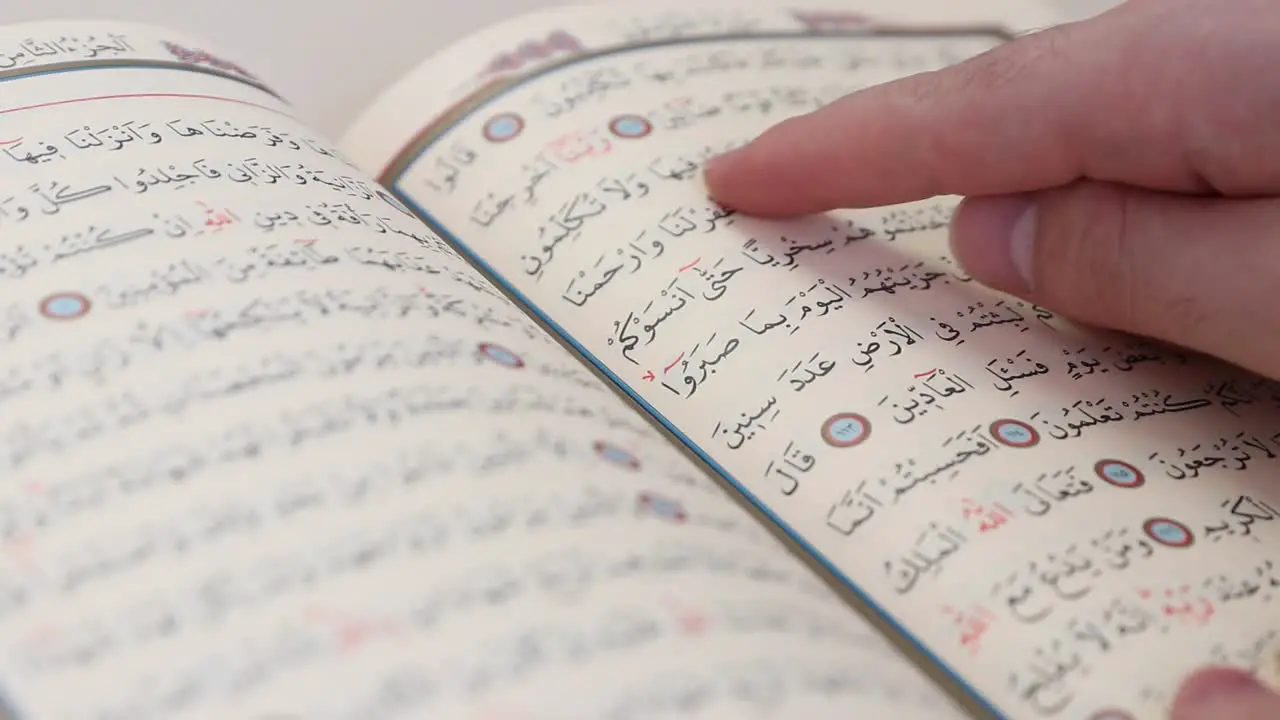 Man Uses Finger to Read Words In The Quran