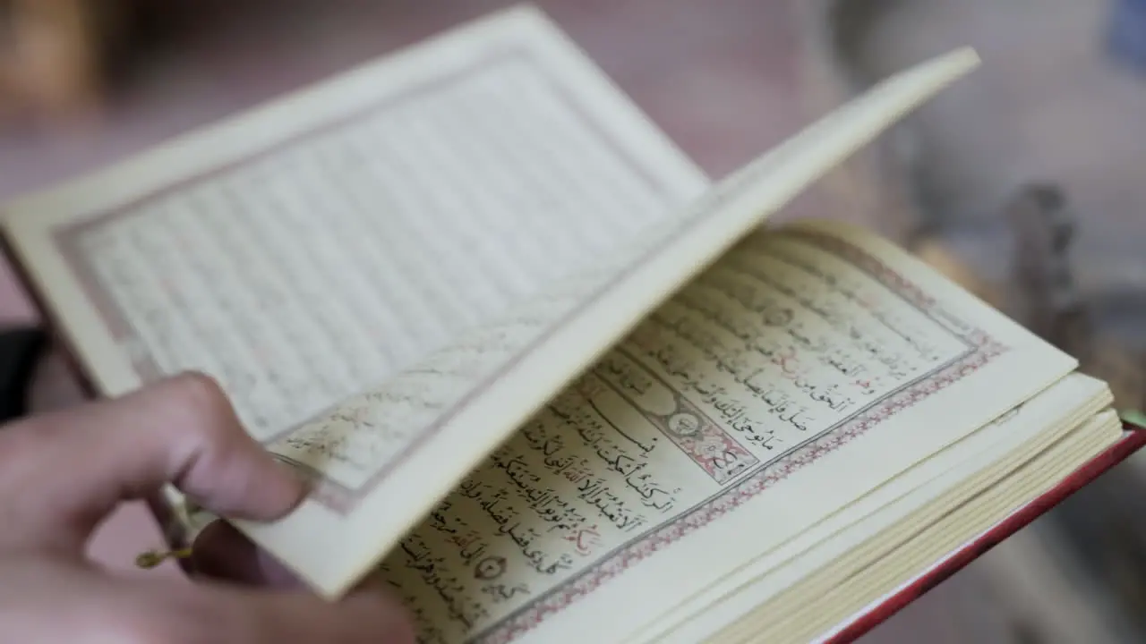 Man turns page in book written in Arabic in mosque Cairo Egypt slow motion