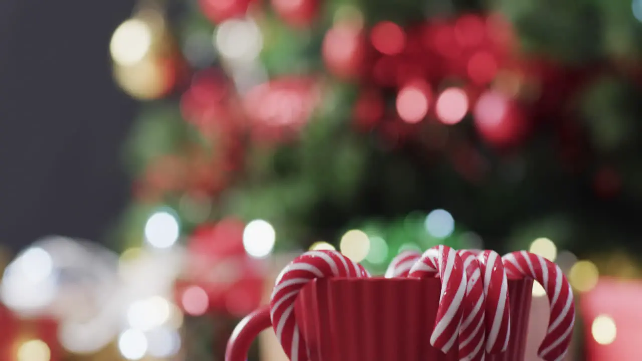 Video of red mug with christmas cnady canes and christmas tree lights with copy space