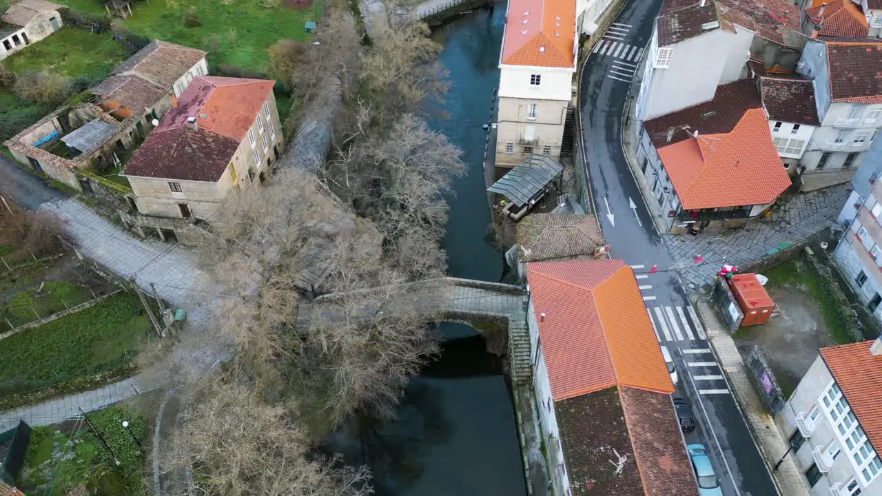 Drone aerial ascend above Roman bridge river molgas Ourense Spain