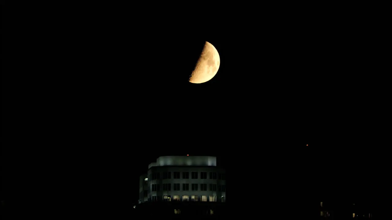 Spectacular half moon glowing above the city