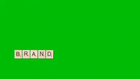 Stop Motion Business Concept Overhead Wooden Letter Tiles Forming Word Brand On Green Screen 1