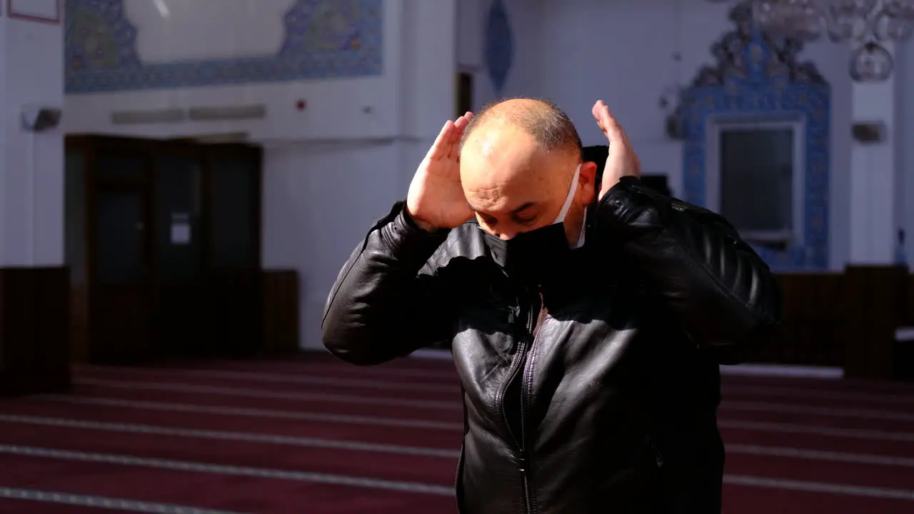 Old Man Worships In A Masked IN Mosque