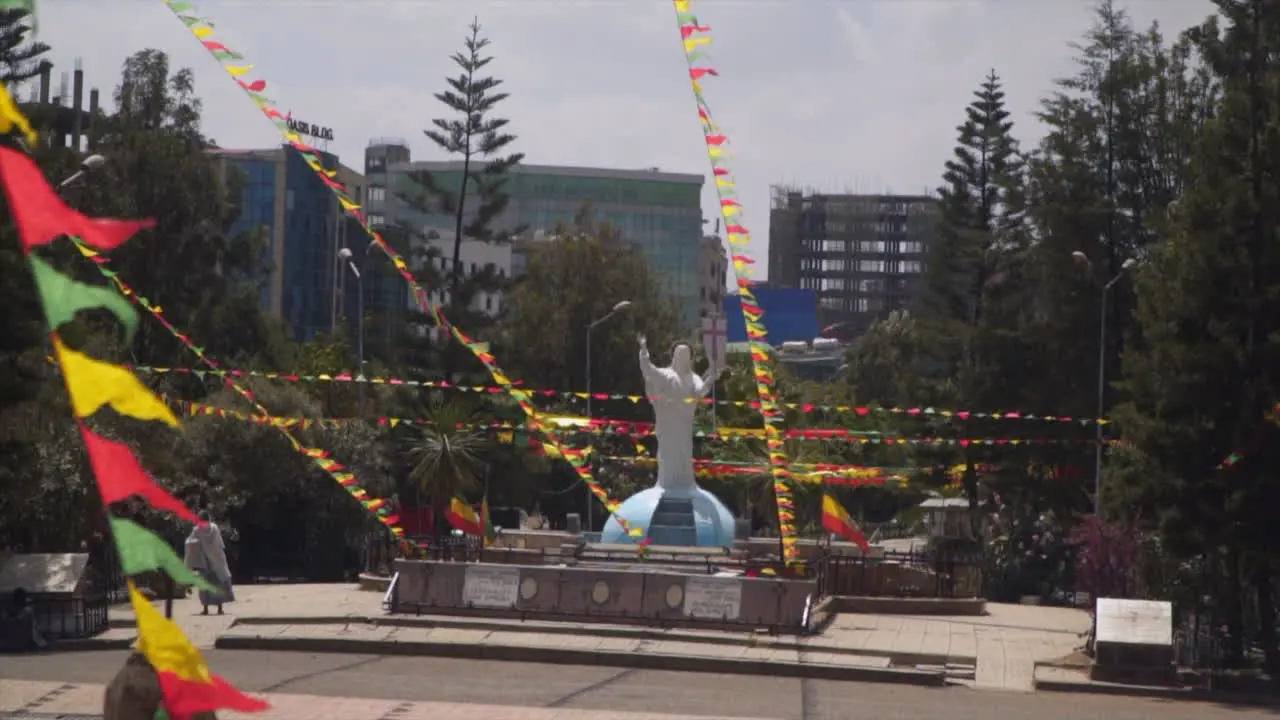 Statue in front of the holy trinity cathedral in Addis Ababa Ethiopia with red green and yellow flags