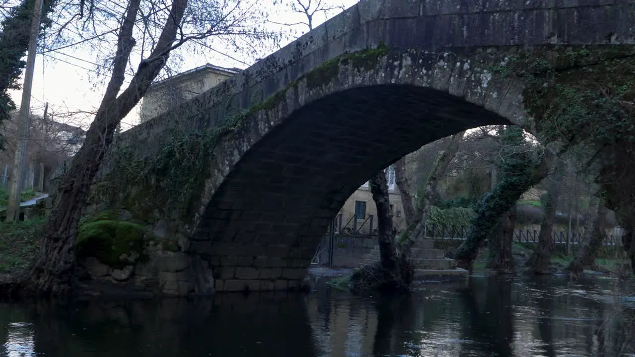 Closeup view from riverbank of river Molgas and roman bridge made from stone