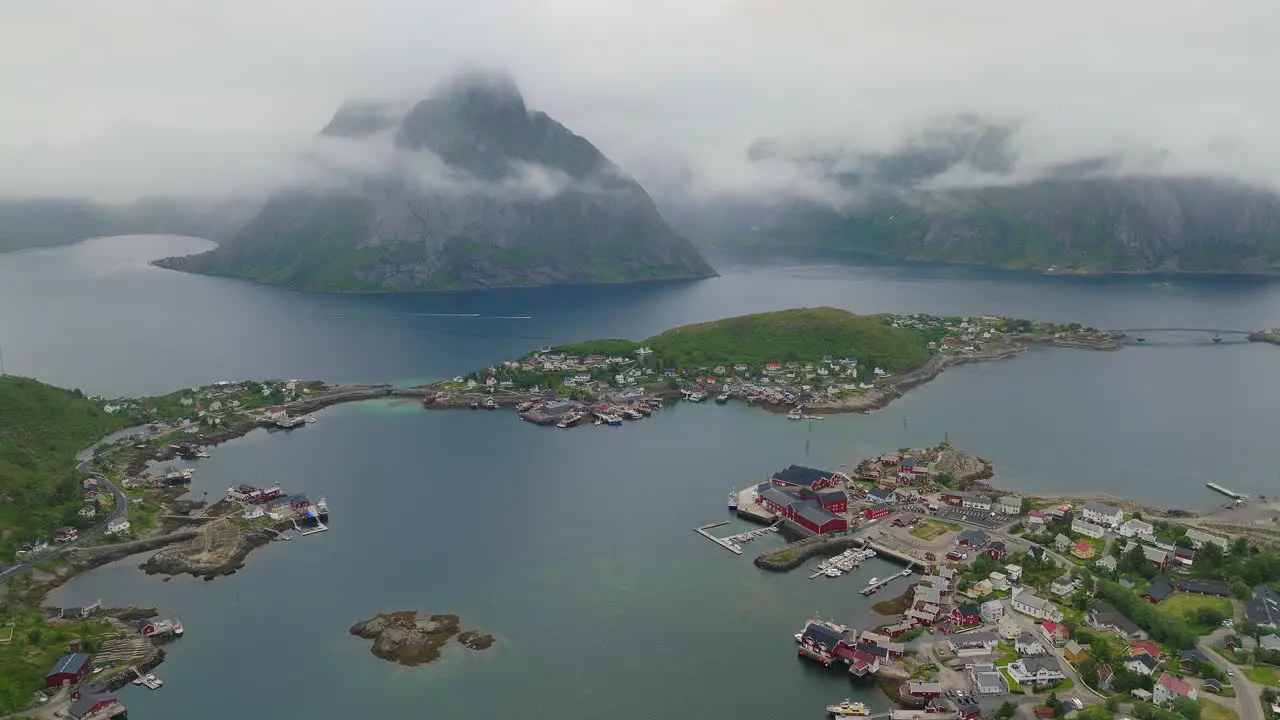 Misty clouds hang below coastal sea cliffs above Reine Lofoten Norway in summer