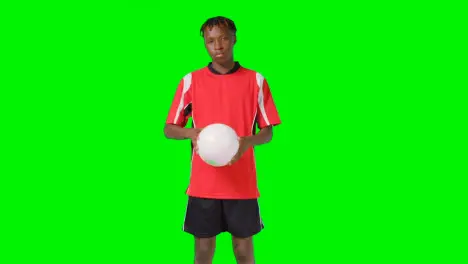 Studio Portrait Of Male Footballer Wearing Club Kit With Ball Under Arm Against Green Screen 1