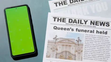 Tracking Shot of Queen Elizabeth Death Newspaper Headlines with Green Screen Phone 04