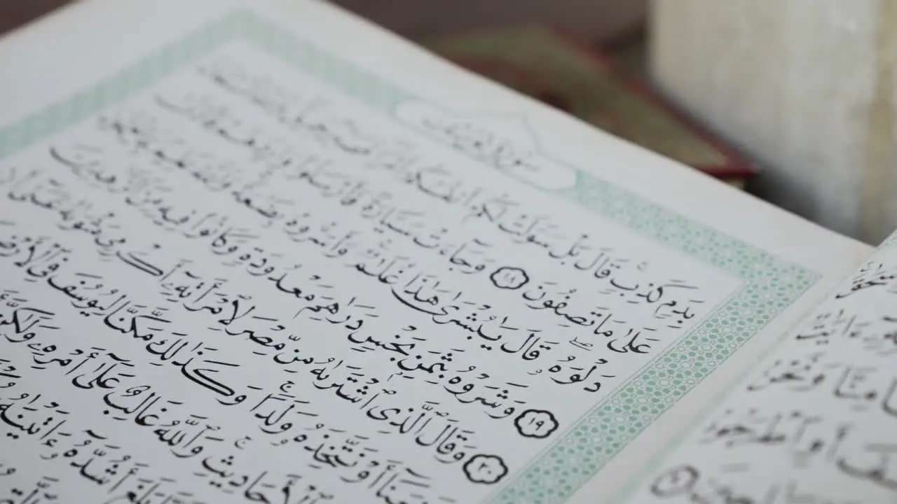 Macro shot of Arabic book in mosque slowing moving back slow motion