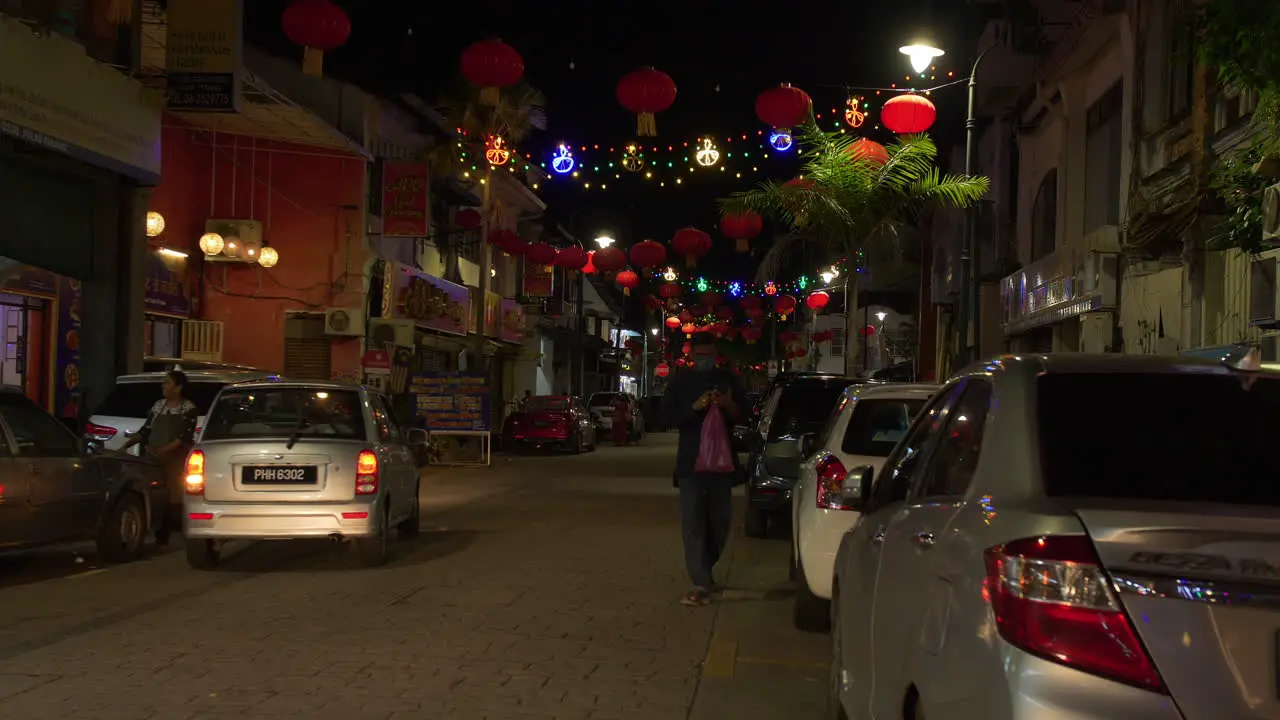 Person Walking Down Busy Street at Night Little India Lantern Lights Malaysia