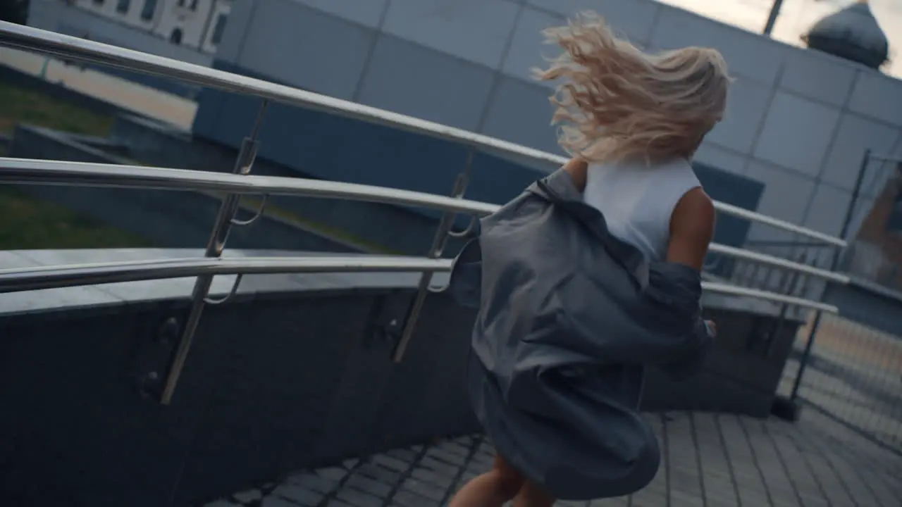 Fit girl running city background near modern urban buildings