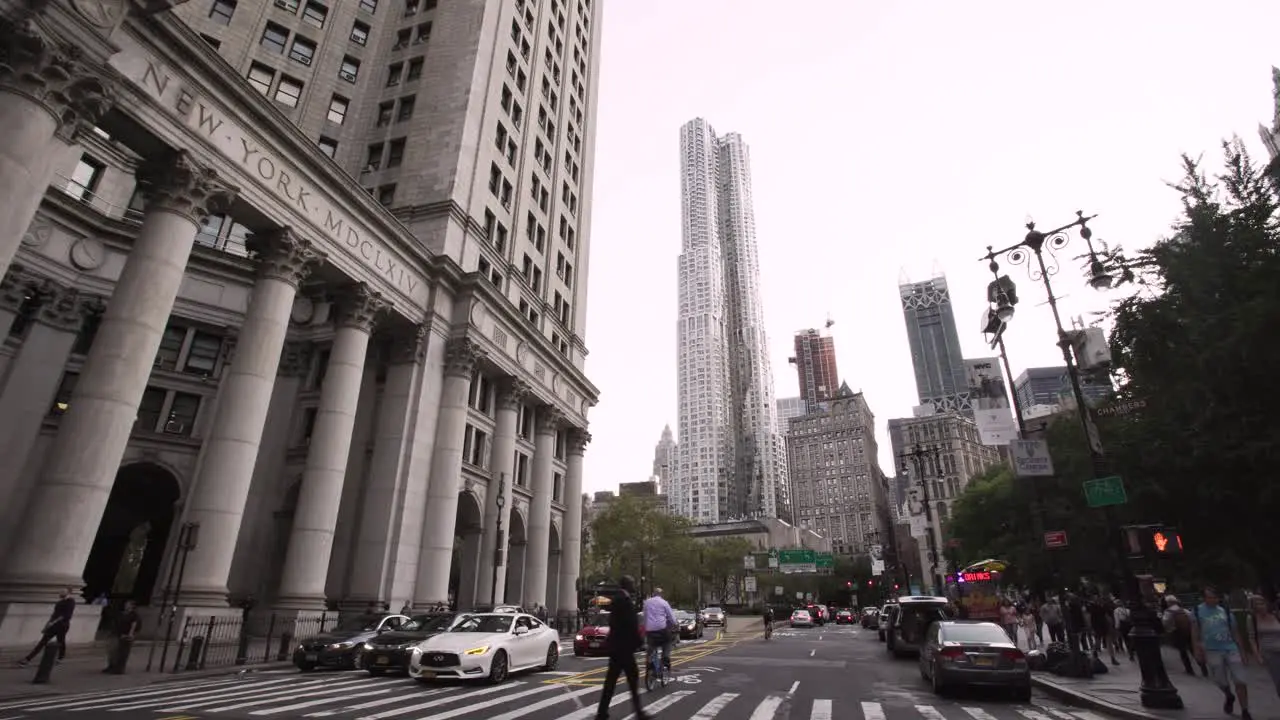 NYC Center Street facing Spruce Street Tower Downtown Manhattan street scene with cars and pedestrians Gimbal pull backwards