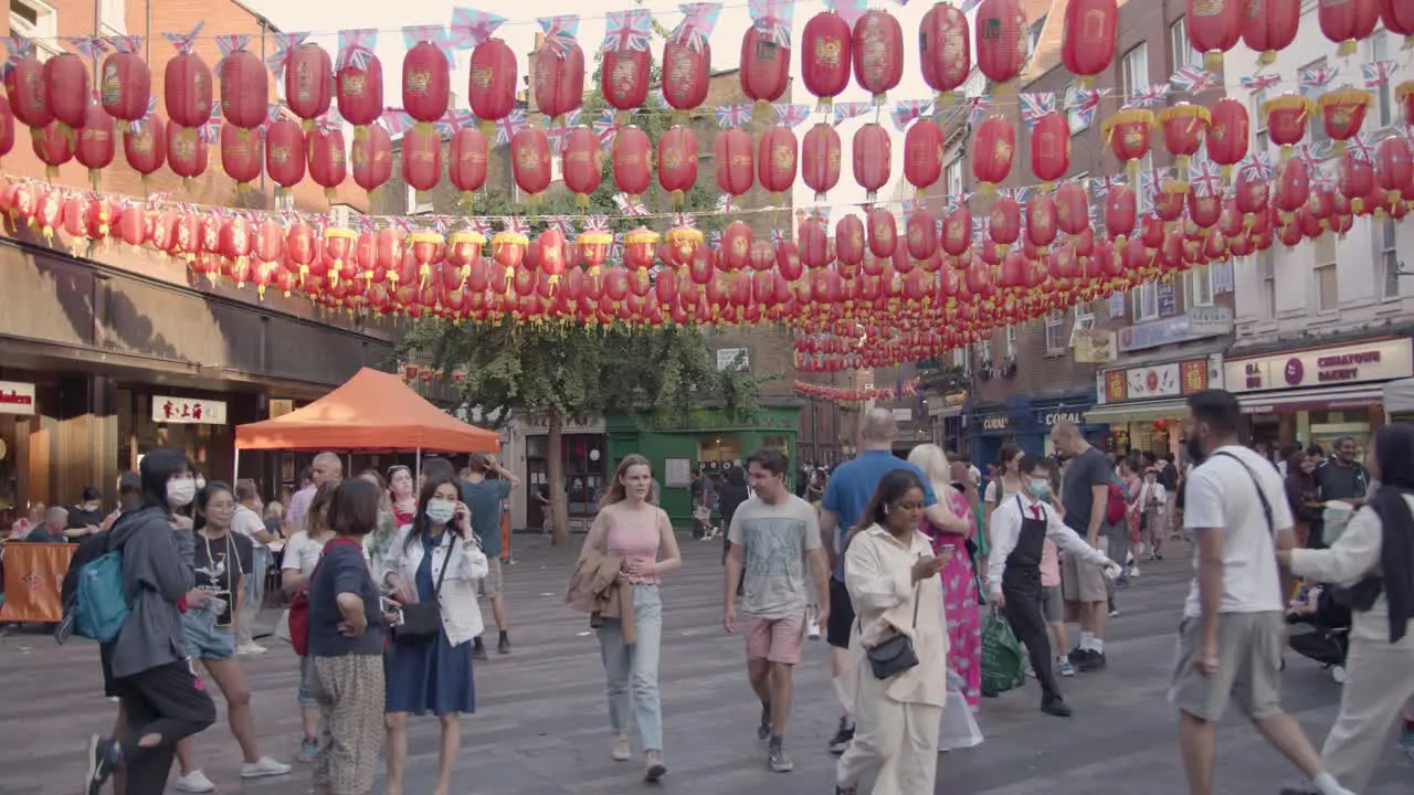 Crowd Of Summer Tourists Walking Through Streets In Chinatown In London England UK