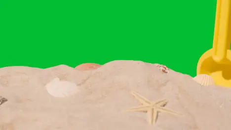 Summer Holiday Concept With Child's Plastic Spade On Sandy Beach Against Green Screen