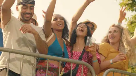 Low Angle Shot of a Group of Festival Goers at the Stage Barrier Enjoying Music