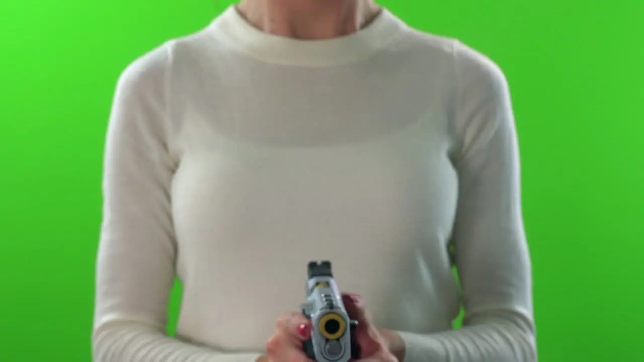 Female pointing gun forward cocking and firing on green screen background