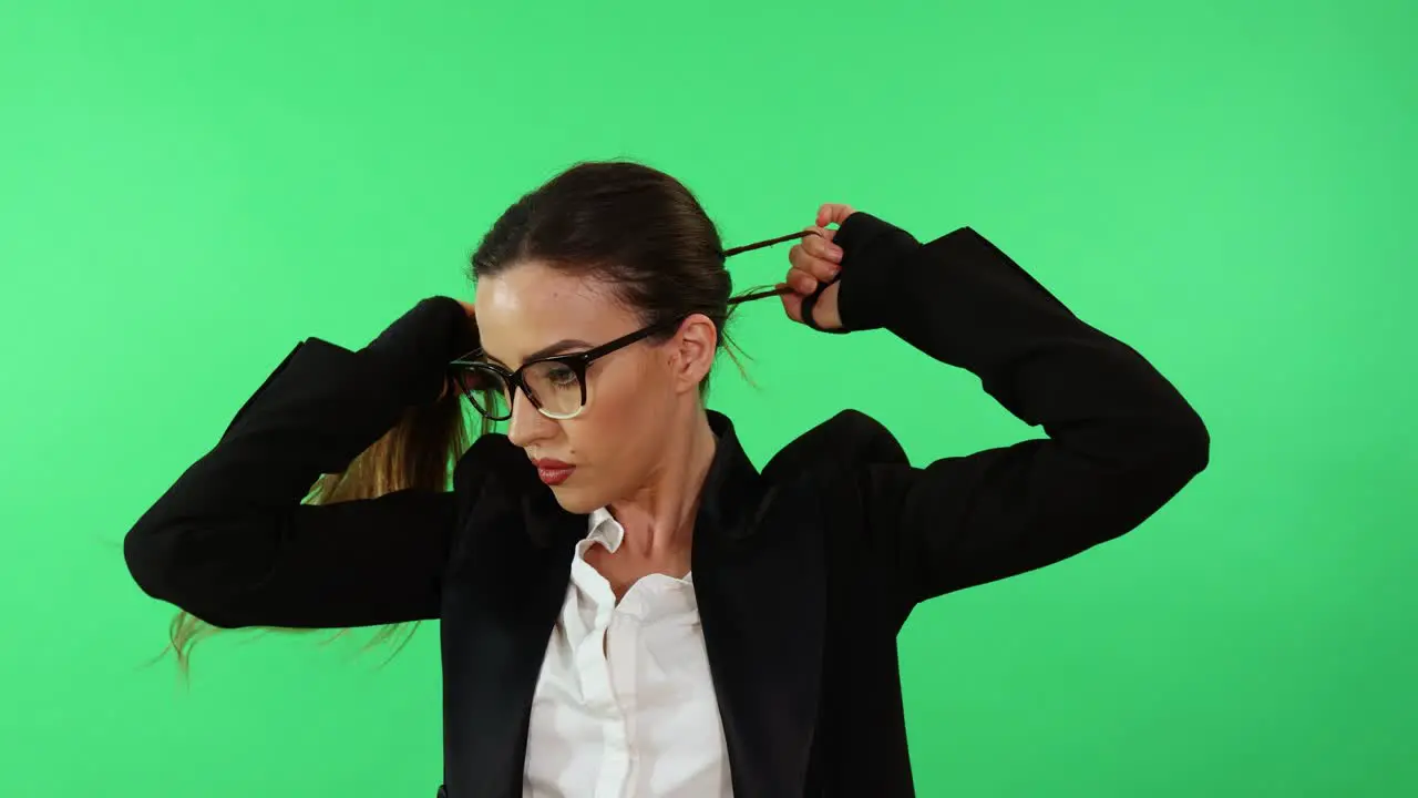 Sexy businesswoman with glasses and business suit arrange her hair with ponytail and gets ready for work day in office wearing punching gloves