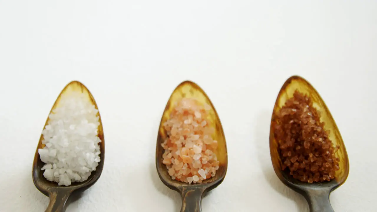 Various types of sea salt in a spoon 4k