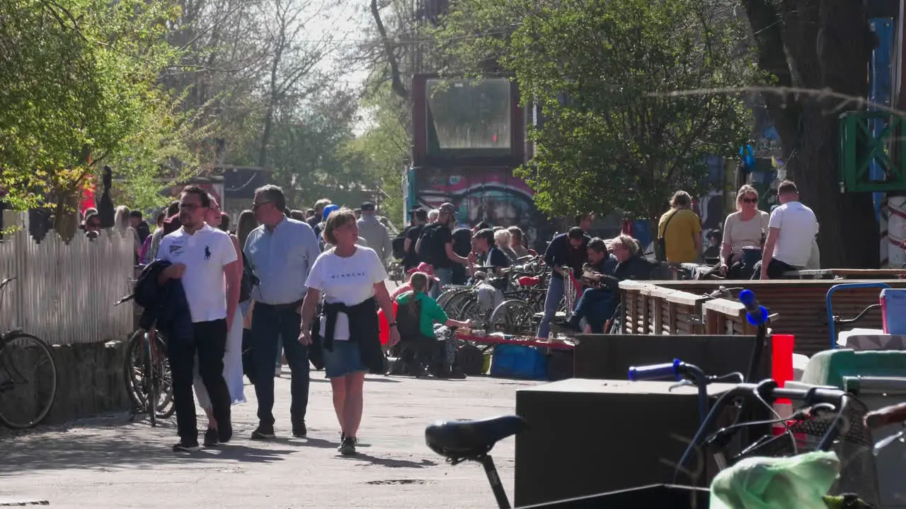 Copenhagen locals and tourists walk by vibrant Christiania