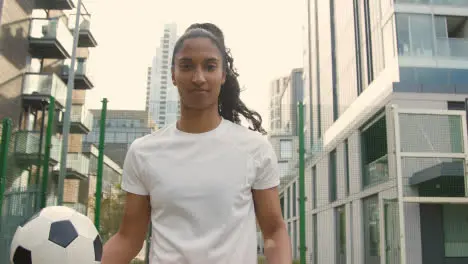 Portrait Of Young Woman Holding Football On Artificial Soccer Pitch In Urban City Area 2