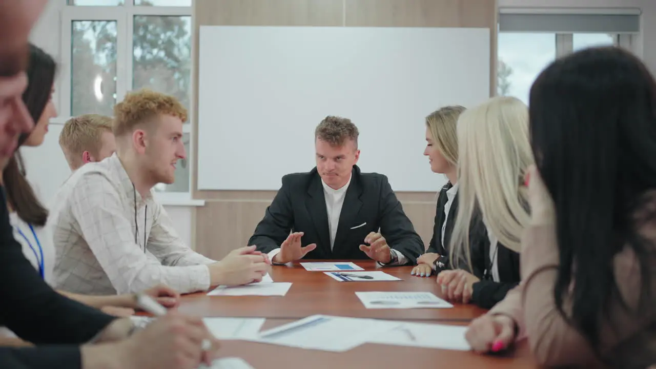 head of company is deliberating with employees and specialists in daily work briefing in conference hall