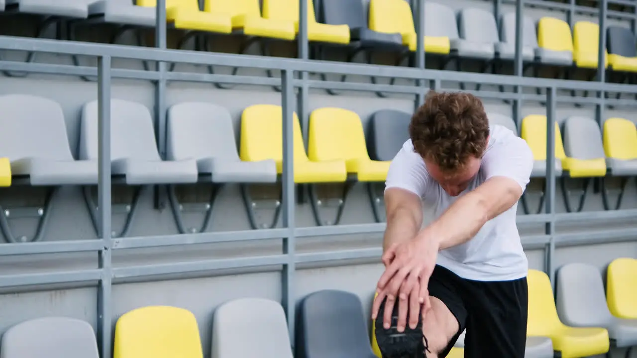 Fitness Young Male Athlete Doing Stretching Exercises In The Stadium 1