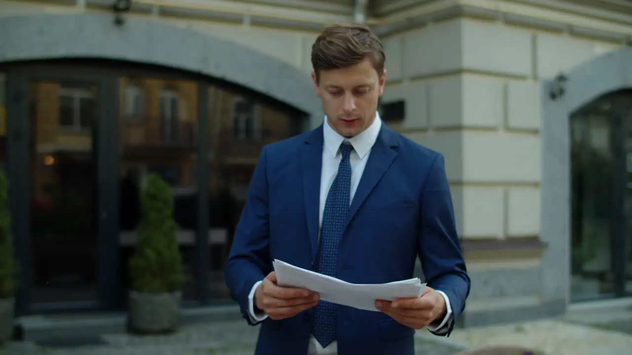 Focused businessman reading financial report outdoors Thoughtful business man