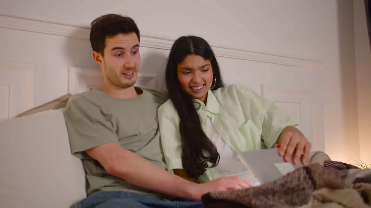 Couple Watching Unpleasant Movie Scene On Laptop Sitting On Bed At Home