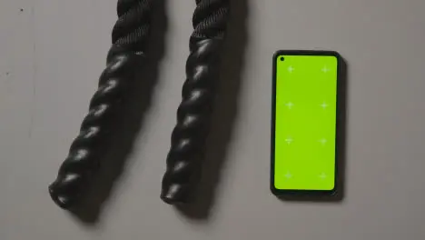 Overhead Studio Fitness Shot Of Hands Picking Up Gym Battle Ropes With Green Screen Mobile Phone On Grey Background 2