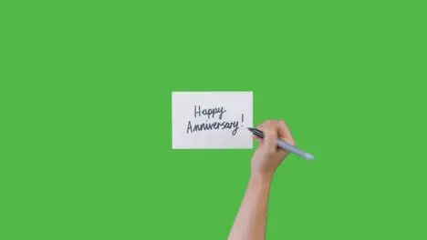 Woman Writing Happy Anniversary on Paper with Green Screen