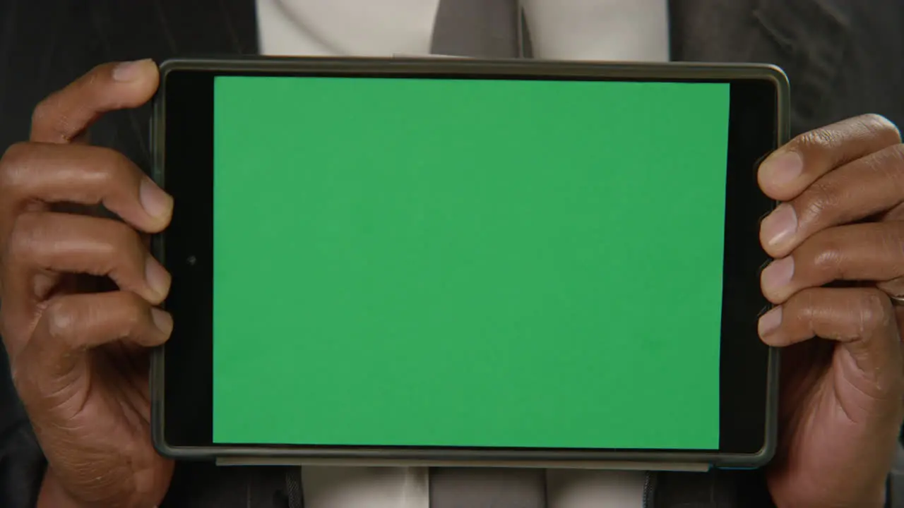 CU Man Holds Tablet at Camera with Green Screen