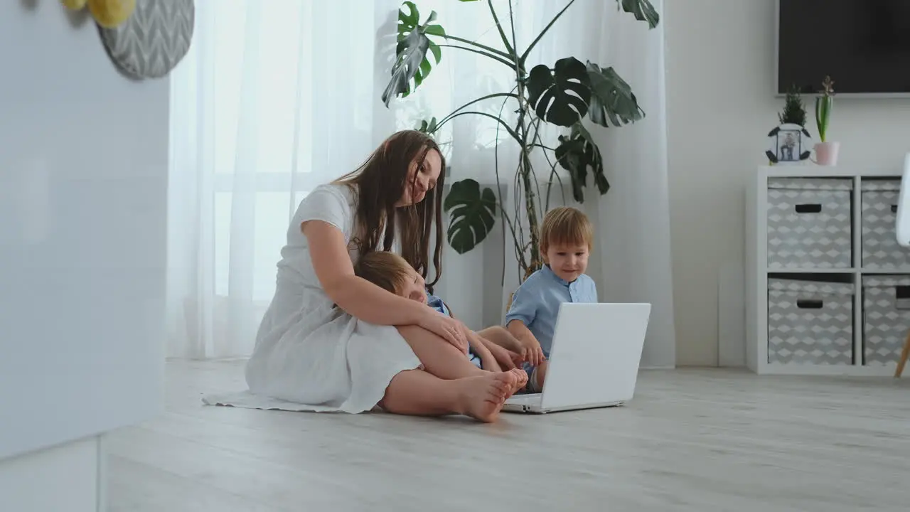 Una Joven Madre Progresista Con Dos Hijos Pequeños Habla Con Su Padre A Través De Una Comunicación Por Vídeo La Tecnología Moderna Es Una Familia Joven