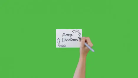 Woman Writing Merry Christmas on Paper with Green Screen