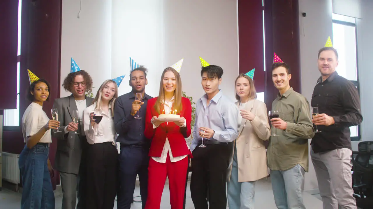 Retrato De Un Grupo De Colegas Multiétnicos Mirando La Cámara Posando Con Un Pastel De Cumpleaños Y Haciendo Un Brindis En La Fiesta De La Oficina