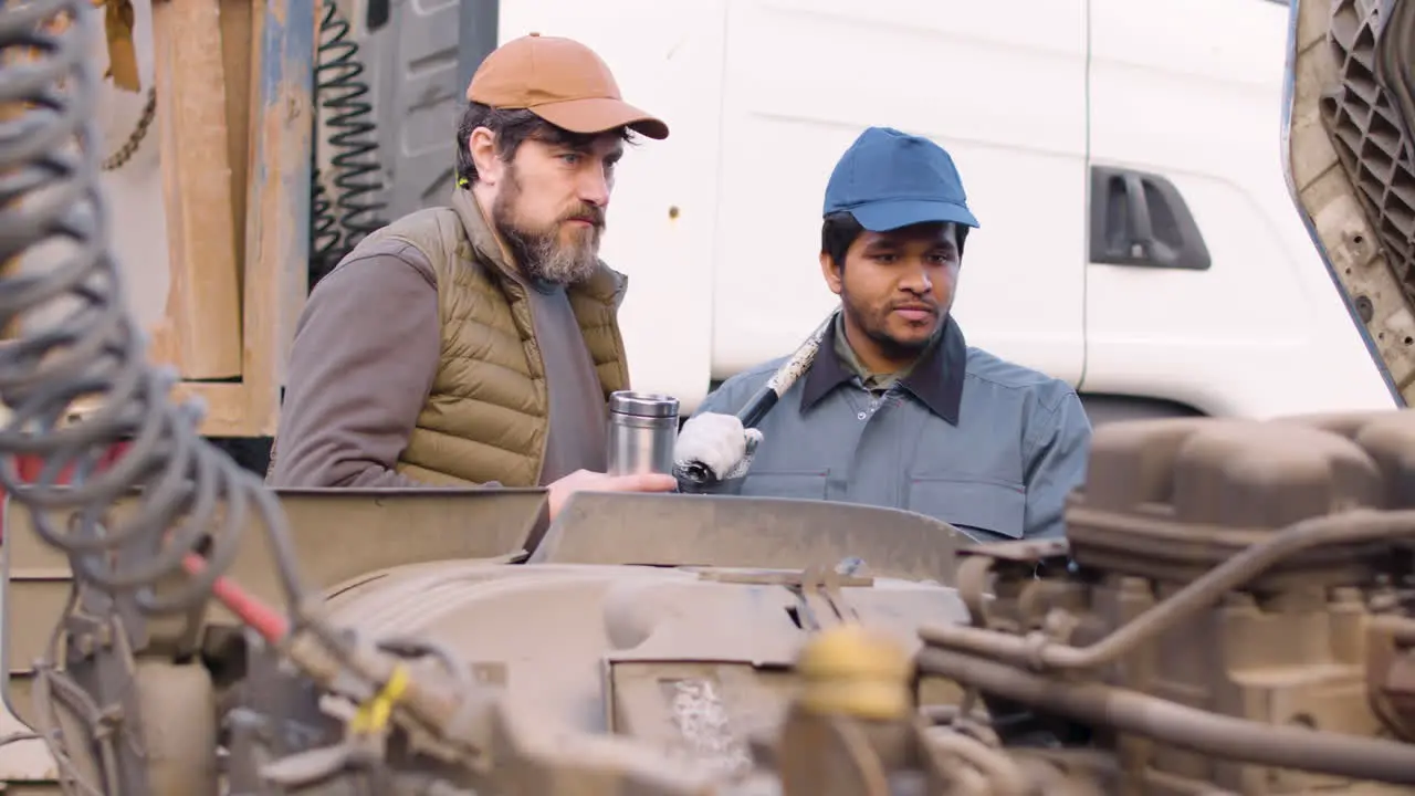 Boss And Worker Checking Truck Engine In A Logistics Park