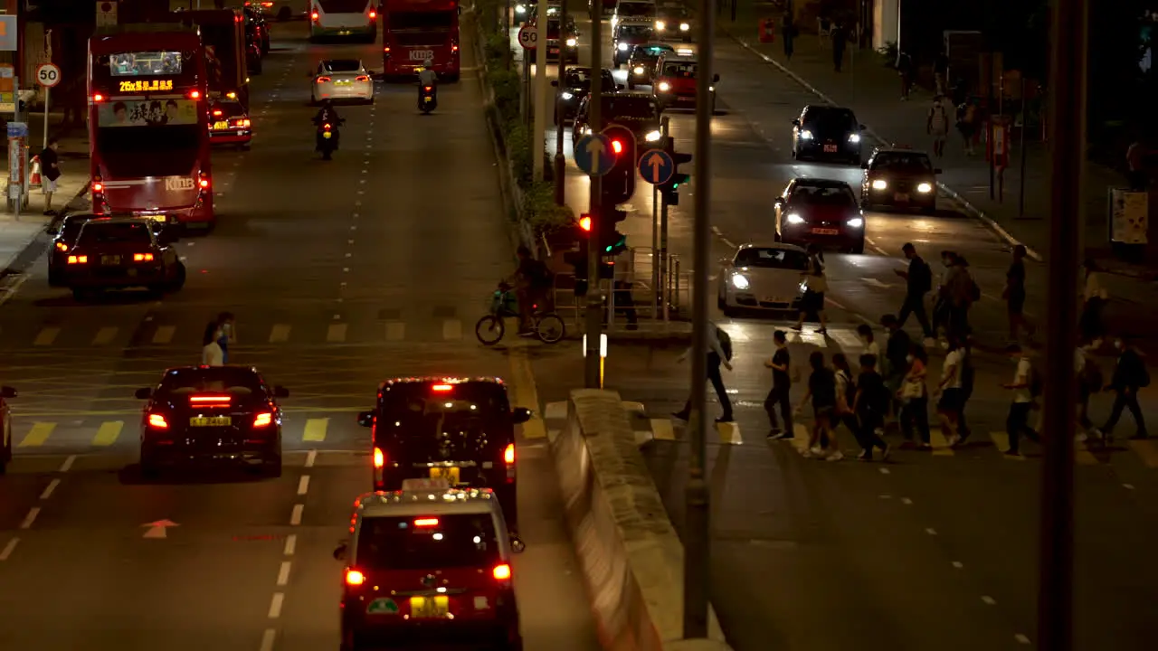 People crossing a crosswalk at night in Hong Kong