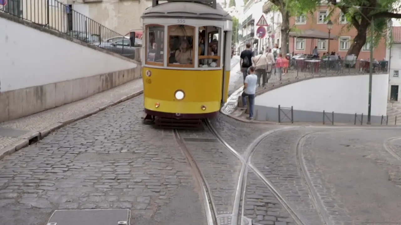 Electrico tram cruising trough the streets of Lisbon front tracking shot