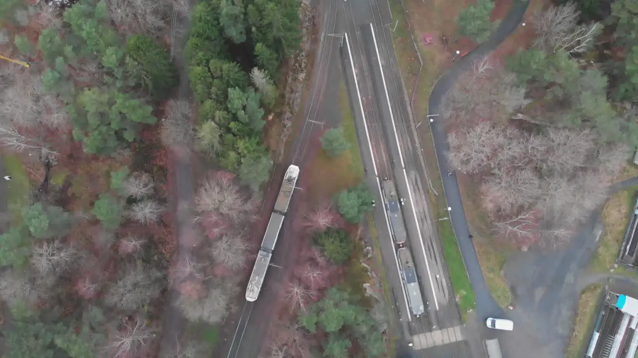 Bird's eye view following a tram as it travels along a railway in Sweden